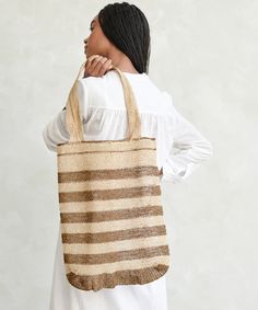 Natural Lao Vine Tote Natural Stripe This versatile and eco-friendly bag is perfect for beach days, grocery runs, and beyond. A completely natural product handcrafted from 100% kudzu vine fiber that grows wildly in northern Laos without any cultivation, irrigation or chemicals. Handcrafted from 100% kudzu vine fiber. Zero waste, organic, vegan, plastic-free, chemical-free, and Fair Trade. Due to the handmade nature of this bag, product may slightly vary as each one is unique. Please note that th Eco-friendly Natural Straw Bag, Eco-friendly Fair Trade Natural Beach Bag, Natural Crochet Bag For Travel, Handwoven Natural Color Beach Bag, Natural Handwoven Natural Fiber Beach Bag, Handwoven Natural Fiber Beach Bag, Fair Trade Natural Crochet Bag For Travel, Eco-friendly Natural Handwoven Beach Bag, Eco-friendly Handwoven Natural Beach Bag