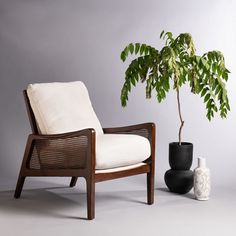 a white chair sitting next to a potted plant