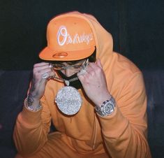 a man in an orange hoodie is covering his face