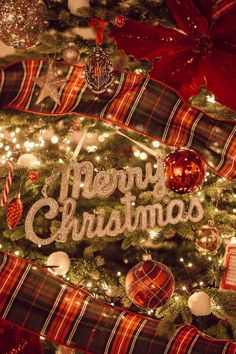 a christmas tree decorated with ornaments and merry lettering on it's side, surrounded by lights