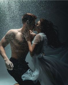 a man and woman are kissing under the water in an underwater photo with bubbles coming from them