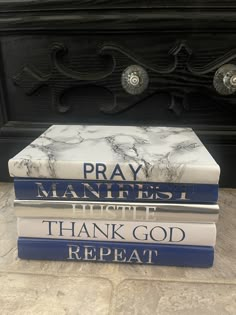 three books stacked on top of each other in front of a black fireplace mantel