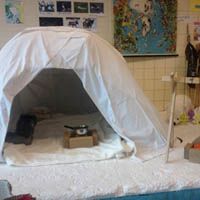 a white tent sitting on top of a bed in a room