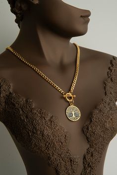 Elevate your style with our Exquisite 22k Gold-Plated Tree of Life Necklace, a perfect blend of elegance and symbolism. This stunning piece features a meticulously crafted Tree of Life pendant, symbolizing growth, strength, and interconnectedness. The necklace is plated in 22k gold, providing a luxurious and radiant finish. The Tree of Life pendant hangs gracefully from a sturdy yet elegant gold chain, secured with a stylish toggle clasp, ensuring both beauty and durability. Ideal for any occasi Luxury Elegant Jewelry With Tree Of Life, Luxury Elegant Pendant Custom Necklace, Luxury Gold Plated Symbolic Necklace, Luxury Gold Plated Necklace With Elegant Design, Luxury Gold Plated Exquisite Necklace, Luxury 22k Gold Exquisite Necklace, Luxury 22k Gold Symbolic Jewelry, Luxury 22k Gold Chain Necklace, Luxury 22k Gold Necklaces