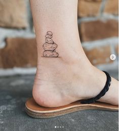 a small stack of rocks tattoo on the ankle