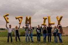 a group of people holding up yellow letters that spell out the word fly in front of them