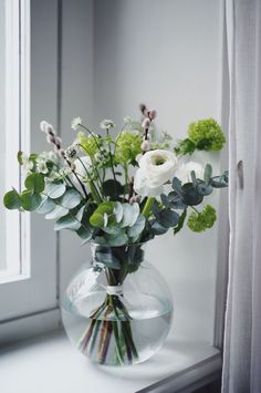 a vase filled with flowers sitting on top of a window sill