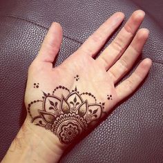 a person's hand with a henna tattoo on it