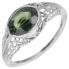 1930's Art Deco rich green sapphire engagement ring. This 1.51ct oval green sapphire is mounted sideways in a filigree 14k white gold setting. The GIA has certified the sapphire as natural, no heat. The striking green hues of the sapphire are complimented by artistic detailing of the band. A true example of the Art Deco era. 1, Natural oval Sapphire, dark yellowish green, no heat and no enhancements, approx. total weight 1.51cts. GIA certificate # 2135499508 14k White Gold Stamped: 14k 1.8 grams Width at top: 8.4mm Height at top: 4.4mm Width at bottom: 1mm Size 5 1/2 and sizable Please Note, we photograph each item as accurately as possible. However, due to monitor/mobile device resolution and calibration, we understand some photos may vary in appearance. If you are not satisfied, we offer Art Deco Green Ring Gia Certified, Art Deco Oval Filigree Jewelry, Oval Filigree Art Deco Jewelry, Luxury Vintage Green Filigree Ring, Art Deco Green Ring, Gia Certified, Green Sapphire Engagement, Green Sapphire Engagement Ring, Gia Certificate, Yellowish Green