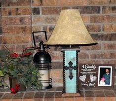 a lamp sitting on top of a brick mantle next to a potted plant and photo