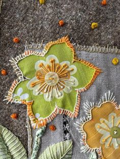 a close up view of some flowers on a piece of fabric with buttons and thread