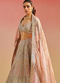 Featuring an enchanting salmon pink organza blouse, adorned with intricate gota patti, mirror work and playful tassels. Elegantly paired with a pink lehenga fully embellished with gota and mirror work and a matching multi shaded ethereal organza dupatta with mirror embellishments. Composition : Organza Care: Dry Clean Only and Vacuum Storage This product can be customized for sleeves, length of blouse and neckline Delivery : 6-8 weeks as the product is hand crafted. Check Size Guide or choose My Studio Iris, Cancan Lehenga, Mirror Work Lehenga, Geometric Mirror, Organza Lehenga, Mirror Embroidery, Organza Blouse, Padded Blouse, Pink Lehenga