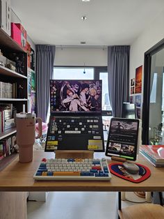 a desk with a keyboard, mouse and computer monitor on it in front of bookshelves