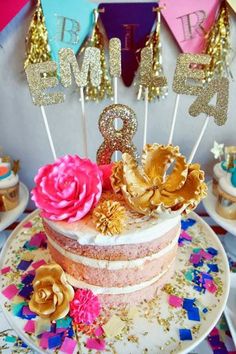 a birthday cake decorated with gold and pink flowers