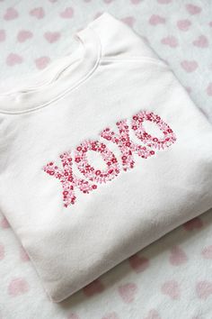 a white sweatshirt with the word pop spelled in red sequins on it's chest