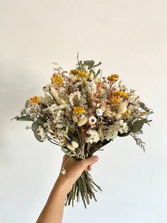 a person holding a bouquet of flowers in their hand