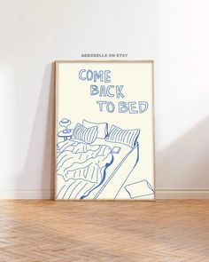 a poster with the words come back to bed on it in front of a white wall