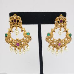 This beautiful earrings set has an excellent finish and gives out an exquisite sense of style. If you are looking for an amazing Fashion Jewelry set for special occasions such as Anniversary, Engagement, Party, Wedding, or for gifting, then your search ends here. Handmade Indian Temple Jewelry, best to wear it for traditional ceremonies or Indian wedding. This bridal jewelry has an ethnic finish. It has Cubic Zircon stones with semi-precious ruby and emeralds. It is a Bollywood style one gram je Elegant Jeweled Chandbalis For Diwali, Traditional Festive Pearl Earrings With Elegant Design, Gold Jeweled Bridal Earrings For Festive Occasions, Gold Jeweled Bridal Earrings For Reception, Festive Gold Jeweled Bridal Earrings, Jeweled Pearl Earrings For Wedding And Festivals, Jeweled Pearl Earrings For Wedding, Traditional Jeweled Pearl Earrings For Wedding, Festive Jeweled Pearl Earrings For Wedding