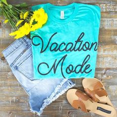 a blue vacation mode shirt with yellow flowers and sandals