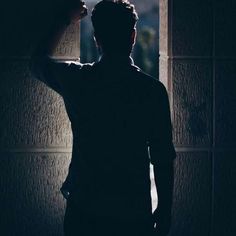 a man standing in front of a window at night