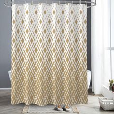 a shower curtain with gold and white geometric designs on it in a bathroom setting, next to a bathtub