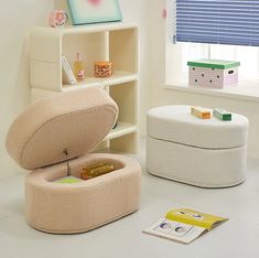 a white room with two round ottomans and a bookcase on the floor, one has a small box in it