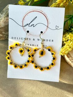 the yellow and black beaded hoop earrings are sitting on top of a white card