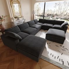 a large sectional couch sitting on top of a rug in a living room next to a window