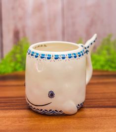 a ceramic whale mug sitting on top of a wooden table