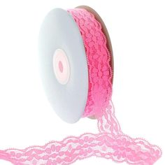 a spool of pink lace on a roll of pink ribbon with a white background