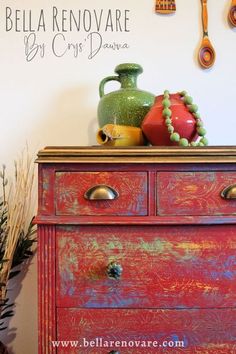 an old dresser has been painted red and green with decorative items on the top shelf