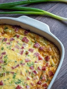 a casserole with ham and cheese in a white dish on a wooden table