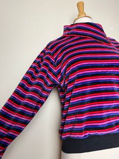 "Vintage 80s Liz Claiborne velvet striped long sleeved shirt with versatile collar. Awesome 80s vintage Liz Claiborne velvet top. Striped in amazing pink, purple, dark grey and red colors. Button collar that can be worn down, as a mock turtleneck, or all the way up. Cotton elastic waist and cuffs. Puffed long sleeves. Hits at waist. Super soft and so 80s! Elastic waist and cuffs are 100% cotton, body is 65% cotton, 35% polyester. Size petite large. Would best fit up to a size medium. Great vinta Winter Long Sleeve Tops With Striped Collar, Purple Long Sleeve 90s Style Top, Purple Long Sleeve 90s Top, Retro Long Sleeve Top With Striped Collar, 90s Striped Long Sleeve Tops, Vintage Long Sleeve Tops With Striped Collar, Striped Collared Tops For Winter, Winter Striped Collared Top, Marimekko Dress