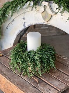 a white candle sitting on top of a wooden table