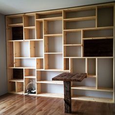 a wooden table sitting in front of a bookshelf filled with lots of shelves