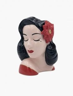 a ceramic figurine with a red flower in her hair and eyes closed, on a white background