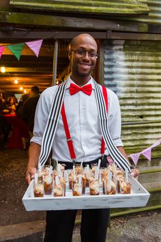 a man holding a tray full of food