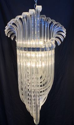 a chandelier made out of glass with lights hanging from the top and bottom