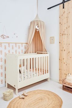 a baby's room with a white crib and rug