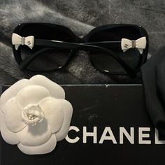 Chanel Sunglasses With Adorable White Bows On Each Side. Slight Few Minor Scratches On Lens. Comes With Case (See Pictures For Damage To Case. Also A Cleaning Cloth From Chanel, The White Iconic Chanel Flower Used To Wrap It. And The Top Part Of The Chanel Box It Came In. Got In 2011-2012 Not Made Anymore! Message Me For Any Other Questions!! Chanel Flower, Chanel Black And White, Chanel Box, Chanel Sunglasses, Chanel Accessories, Over Sized, White Bow, Black Sunglasses, Both Sides