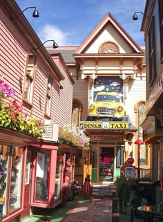 an alley way with shops and parked cars