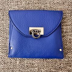 This Salvatore Ferragamo Wallet Is A Triumph Of Style And Design. Finished In Textured Bright Blue Leather, This Wallet Folds Out To Reveal Many Card Pockets And Long Pockets For Cash. This Is Secured By A Silver-Tone Twist Lock. The Back Pocket Opens To An Accordion Fold Compartment. Exterior Material Leather Interior Material Nylon Length 5” Width 0.39” Height 4” Hardware Silver Tone Formal Blue Bags With Card Slots, Blue Envelope Bag For Daily Use, Compact Blue Bags For Daily Use, Compact Blue Coin Purse For Everyday Use, Compact Blue Wallets For Daily Use, Blue Leather Wallets For Formal Occasions, Blue Leather Formal Wallets, Formal Blue Leather Wallet, Elegant Blue Wallet With Coin Pocket