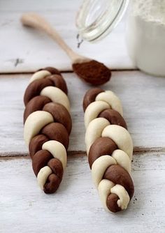 chocolate and white pretzels are sitting on a table next to a jar of milk