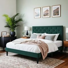 a bedroom with green headboard and white bedding, two framed pictures on the wall