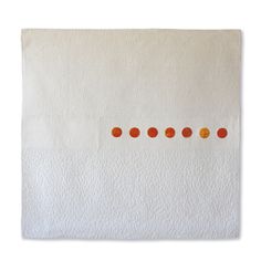 a white towel with orange dots on the front and back of it, against a white background