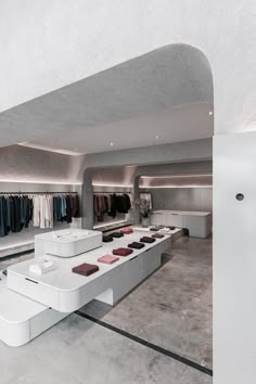 the inside of a clothing store with clothes on racks