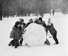 children playing in the snow with a large snowball that looks like it has been built into