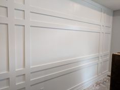 an empty room with white paneling on the walls