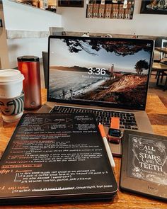 an open laptop computer sitting on top of a wooden table next to a cup of coffee