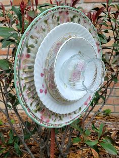 three plates stacked on top of each other in front of a tree with red leaves